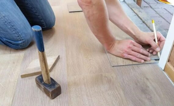 A Man Inserting Wooden Floor Boards on the Floor
