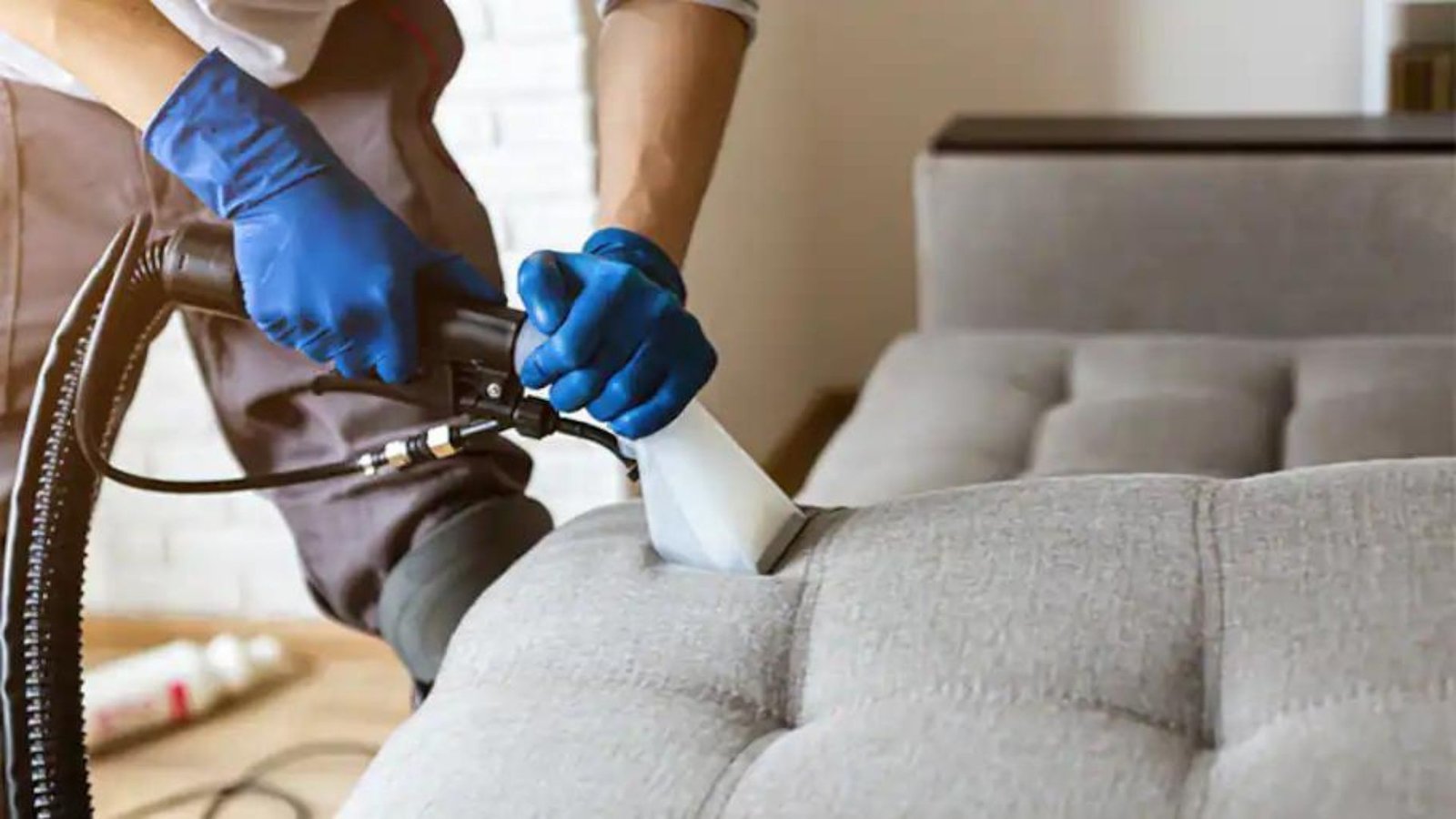 A Person Vacuuming a Sofa 